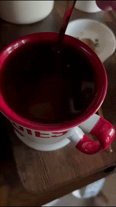 Café mezclándose en una taza blanca con rojo (estilo M&Ms)